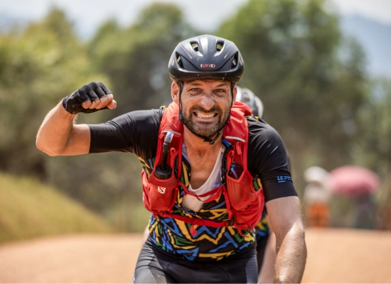 Strong cyclist is raising his fist out of triumph after conquering a hill in Rwanda